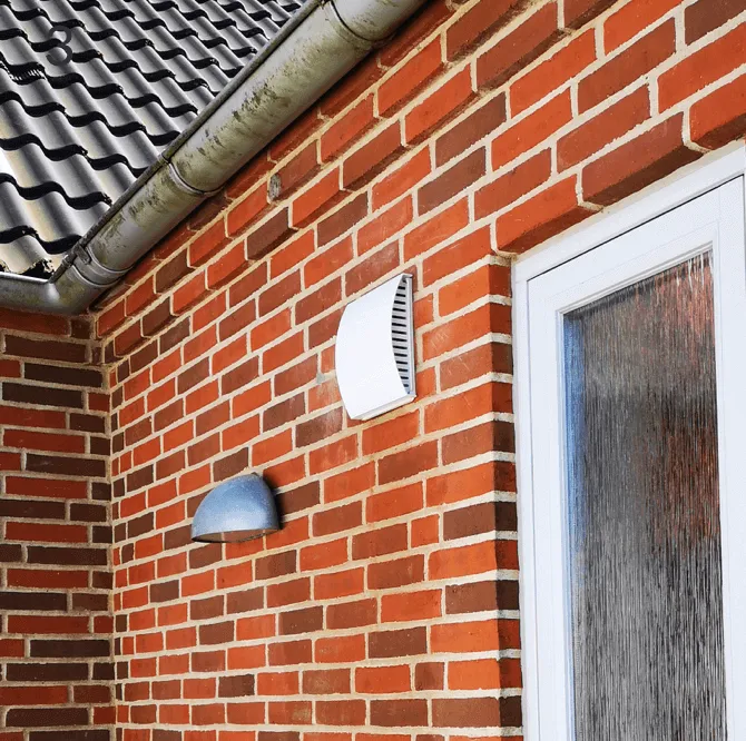 Ventilationsenhed monteret på murstensvæg